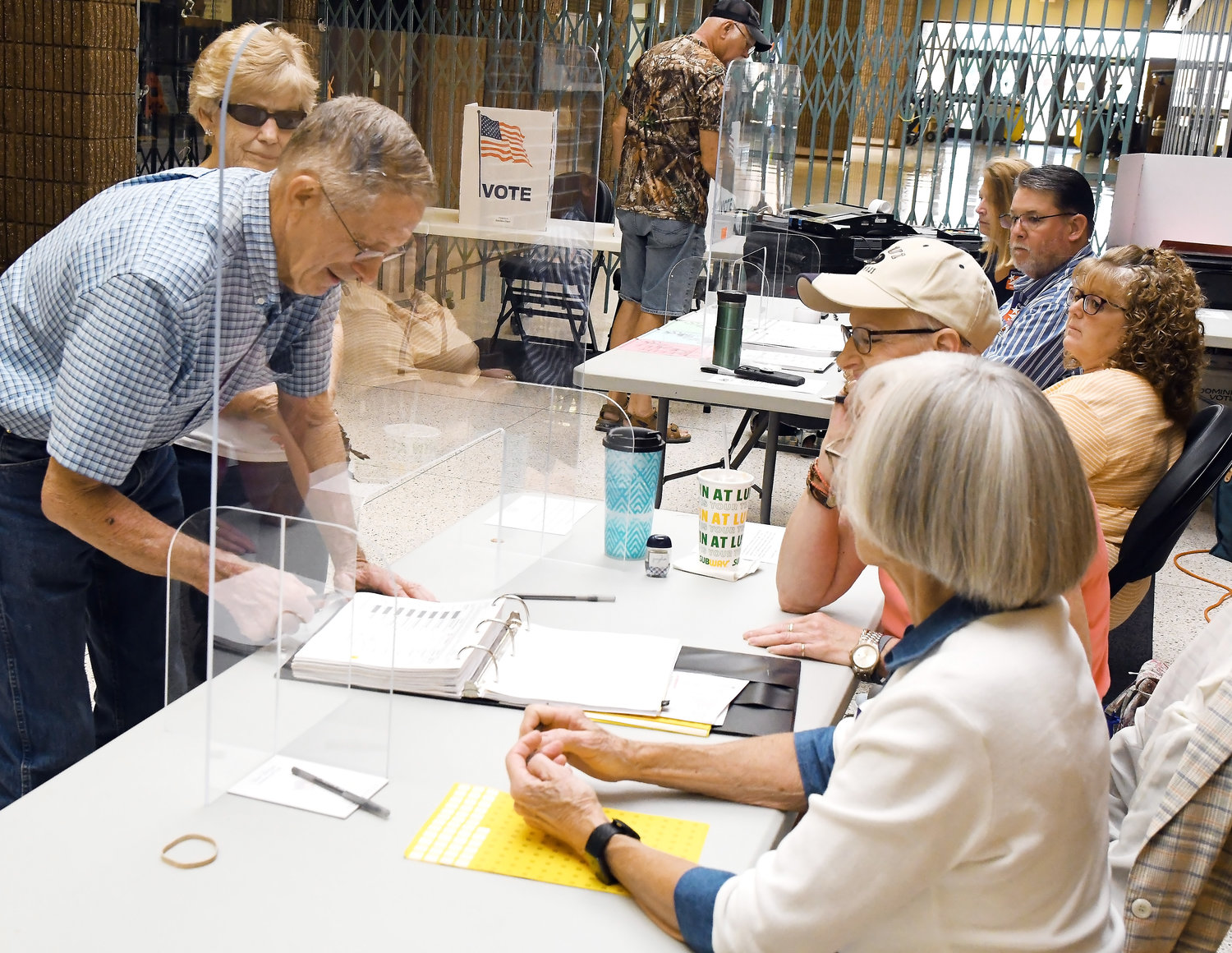 ROGER BILES and his wife, Joyce, sign in to vote early Tuesday afternoon at the Rural Canaan precinct at Owensville High School in the Primary Election. They were in a group of 15 voters in a 20-minute period which brought the turnout to 240 participants.